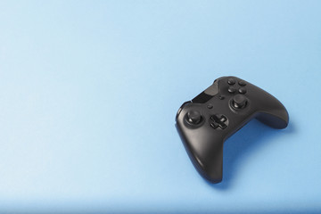 Gamepad on a blue background. Concept of the game in the console or computer. Rest after work. Cybersport. Flat lay, top view © Alex