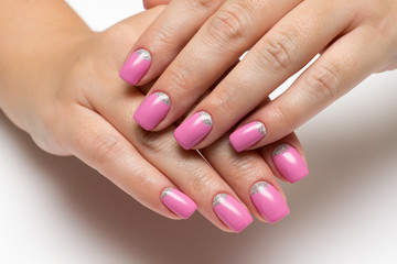 pink manicure with silver on short square nails on a white background close-up