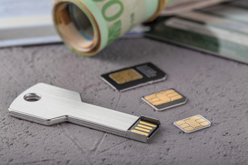 Three SIM cards of different sizes lie on a rough surface. Close-up.