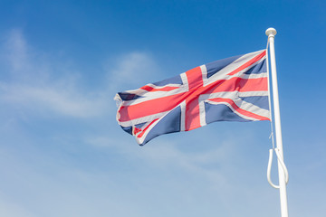 Union Jack Flag Flying From a Flagpole Under a Blue Sky