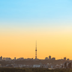 Fototapeta na wymiar City sunset with TV tower and buildings silhouette on orange skyline