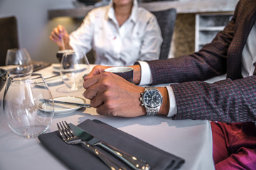 Image of loving couple is spending time together in modern restaurant. Attractive young woman and handsome man in suit are having lunch.