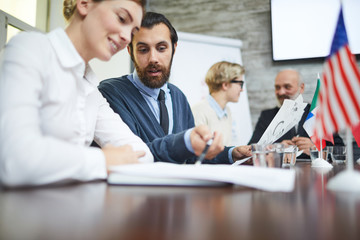 Bearded businessman explaining his colleague point in document during conference