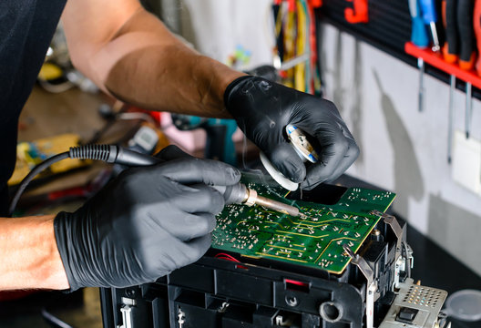 man solder a chip in a workshop close-up