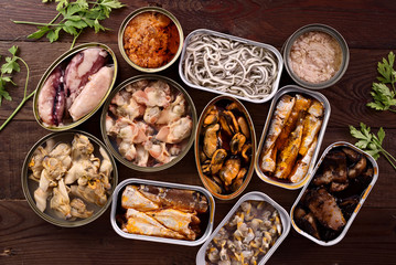 top view of group of open cans of seafood on wood