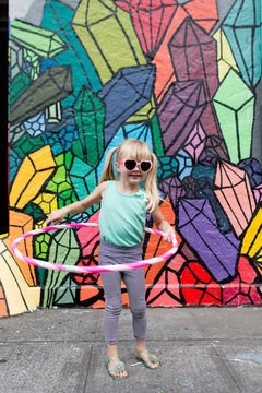 young girl with hula hoop and sunglasses