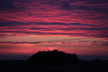 Sonnenuntergang über den Bäumen. Nebel, Herbstfarben und dramatischer Himmel