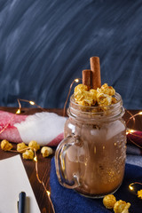 cocoa with popcorn and cinnamon on a slate background with lights