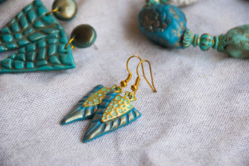 Indian bohemian style jewelry with tuquoise gold earrings. Fashion jewelry. Turquoise color  background.Boho style.