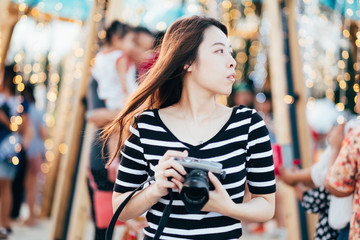 Woman traveler be smile with her camera and beautiful bokeh background,Holiday relaxation concept.
