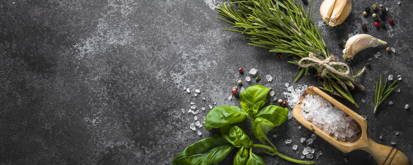 Spices and herbs over black stone table. 