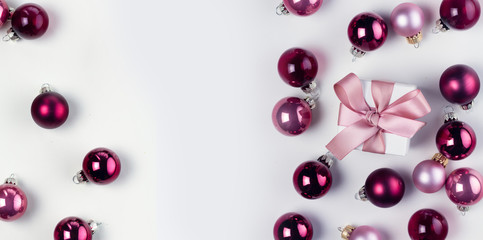 Christmas flat lay scene with pink abd violet glass balls and gift box, banner with copy space on white