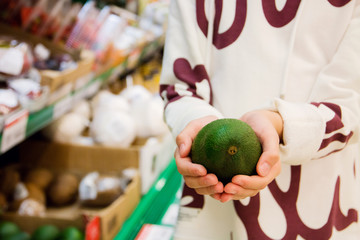Vegetarians and fresh fruit and vegetables on the nature of the theme: human hand holding an avocado