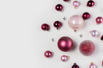 Christmas flat lay scene with pink glass balls and gift box, copy space on white desk