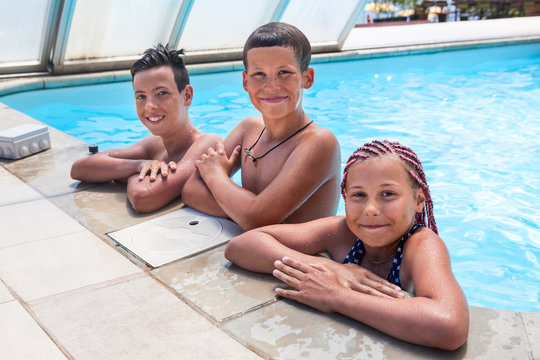 Three Happy And Smiling Kids Looking At Camera While Standing In Watering Hole