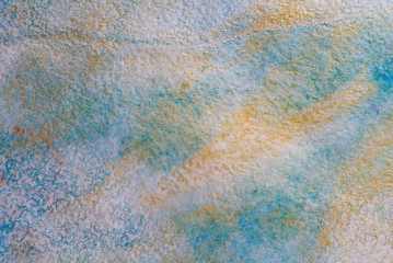 Blue-golden textured watercolor background, abstraction paint bleed. with a texture of special watercolor paper