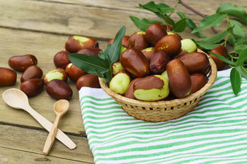 Obraz premium Braided Cup with ripe fruits of the jujube (lat. Ziziphus jujuba) on an old wooden table