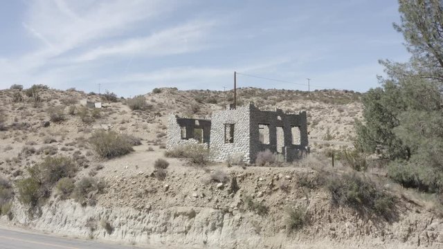 Aerial pullback shot of a barren desert land with some small shrubs.