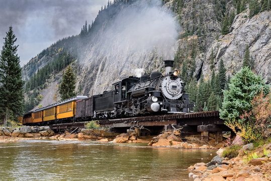 Steam Train Crossing a Trestle Bridge in the Mountains