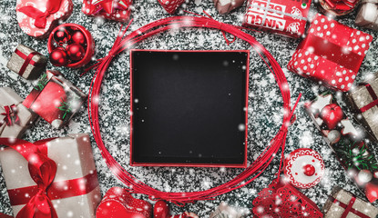 Red circle from decorative wands, with opened black Xmas present box, package and space for text...