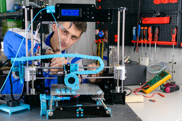 Fototapeta premium Young designer engineer using a 3D printer in laboratory