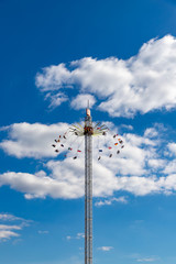 Obraz premium Very large chain carousel in front of blue sky with white clouds. Worms, 