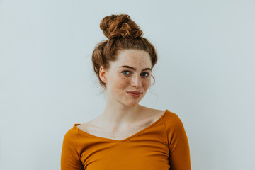 Woman portrait. Style. Beautiful blue eyed girl with freckles is looking at camera and smiling, on...
