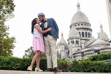 French couple kissing in front of Sacre Coeur in Paris Montmartre