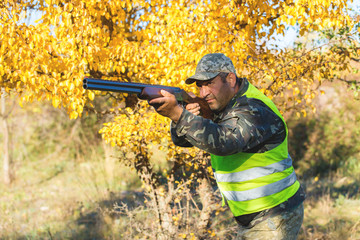 Hunter with a german drathaar and spaniel, pigeon hunting with dogs in reflective vests	