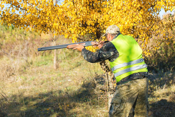 Hunter with a german drathaar and spaniel, pigeon hunting with dogs in reflective vests	