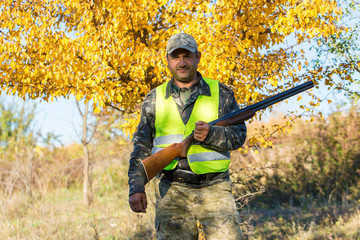 Hunter with a german drathaar and spaniel, pigeon hunting with dogs in reflective vests	