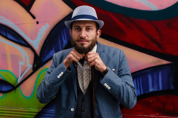 Portrait of a thinking hipster man with grafitti in background