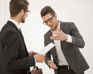 business colleagues discussing a working paper while standing in the office