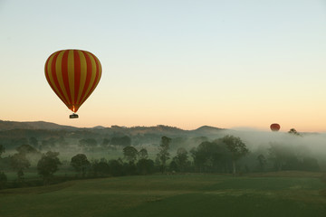 Naklejka premium Hot Air Balloon flight over Gold Coast Hinterland, Queensland, Australia at sunrise in mid winter
