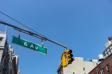 new york city signaling lights high up 6 ave green street sign buildings and water towers clear...