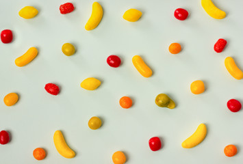 Variety of colorful candy pattern on pastel background.