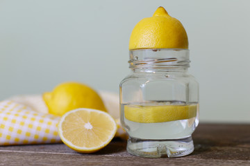 lemon juice in a jar and lemons on a wooden table