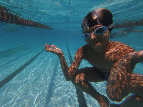Boy posing underwater in swimming pool