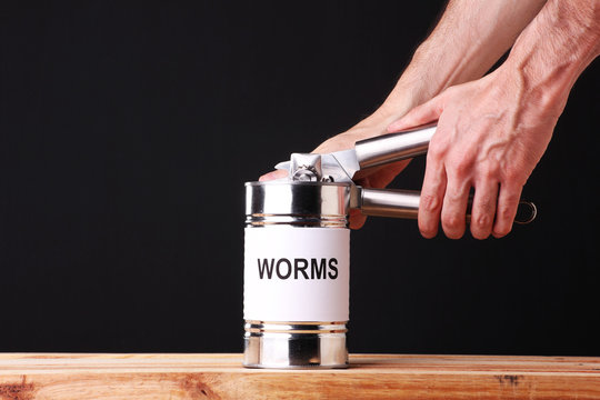Unrecognizable person opening a can of worms.  Creating a situation that will cause problems