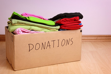 Box with clothes for donations on a laminate floor