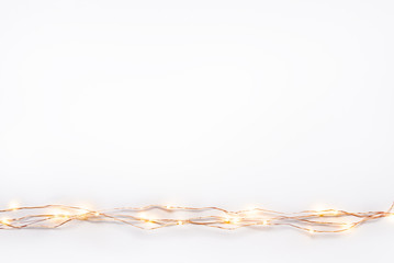 Christmas lights garland border over white background. Flat lay, copy space. © dil_ko