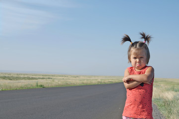  resentful child is standing and don't want to go anywhere defend own position . Little girl in...