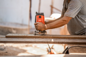 Man doing woodwork in carpentry. Carpenter work on wood plank in workshop
