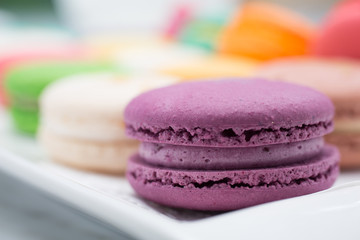 colorful magaroon is placed in a white ceramic dish. Elegant marble dining table with coffee table.