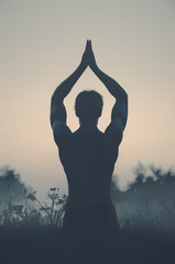 silhouette of a man doing yoga