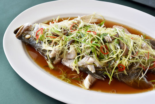 Fish steamed in soy sauce, Snapper boiled with ginger and spring onion sliced, Traditional Chinese cooking style, Healthy clean diet food.