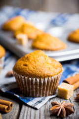 Homemade atutumn muffins with pumpkin, apples and spices on the rustic background. Selective focus. 