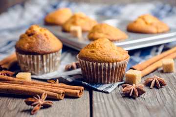 Homemade atutumn muffins with pumpkin, apples and spices on the rustic background. Selective focus. 