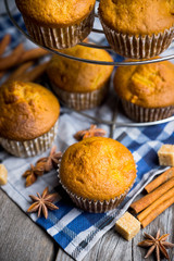 Homemade atutumn muffins with pumpkin, apples and spices on the rustic background. Selective focus. 