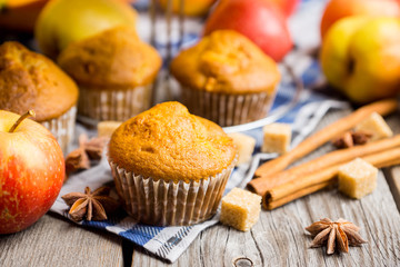 Homemade atutumn muffins with pumpkin, apples and spices on the rustic background. Selective focus. 